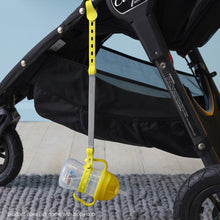 a b.box lemon sippy cup attached to a b.box lemon sherbet connect a cup hanging on the side of a stroller pram push chair