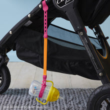 a b.box lemon sippy cup attached to a b.box Strawberry Shake connect a cup hanging on the side of a stroller pram push chair