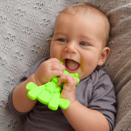 Young Baby Boy Smiling holding a Bambeado Little bamBAM Silicone Teether Lime