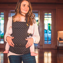 mother wearing a young girl in a polka dot beco gemini on her front 