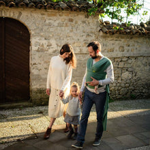 a family walking with a toddler and newborn in the wrap
