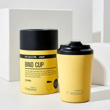 bright yellow cup with black lid and packing in the same colour