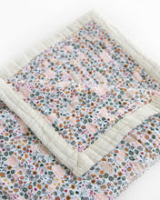 150cm x 180cm double sided printed blanket with white background covered in tiny flower prints pink, rust, green, blue, mustard with the beige trim