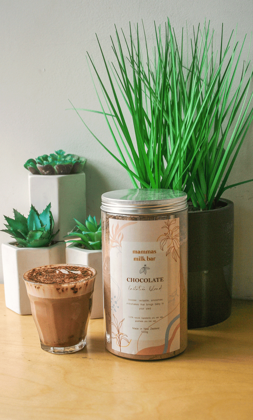 pot plants with succulents, a clear glass filled with a delicious lactation hot chocolate sitting next to a large jar