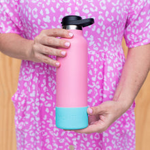 person wearing a bright pink Dres with white spots holding a pale bold pink drink bottle with an iced berry bright aqua teal bumper