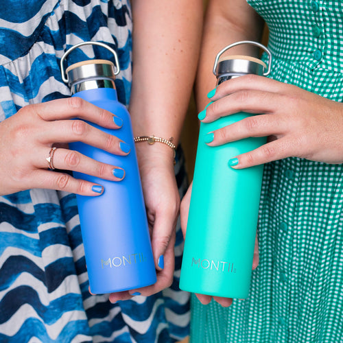 two people holding a blue and green drink bottle wearing matching clothes and painted nails with the same colours