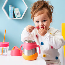 Young girl eating food from a b.box strawberry shake insulated food jar